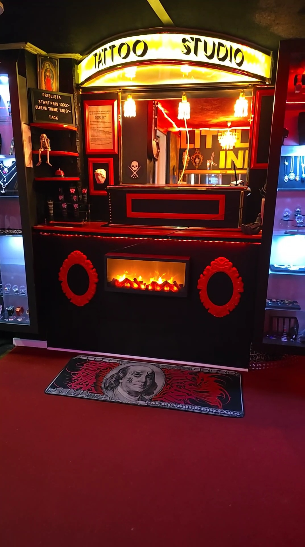Interiören i Little Ink Tattoo med upplyst Tattoo Studio-skylt och receptionsdisk